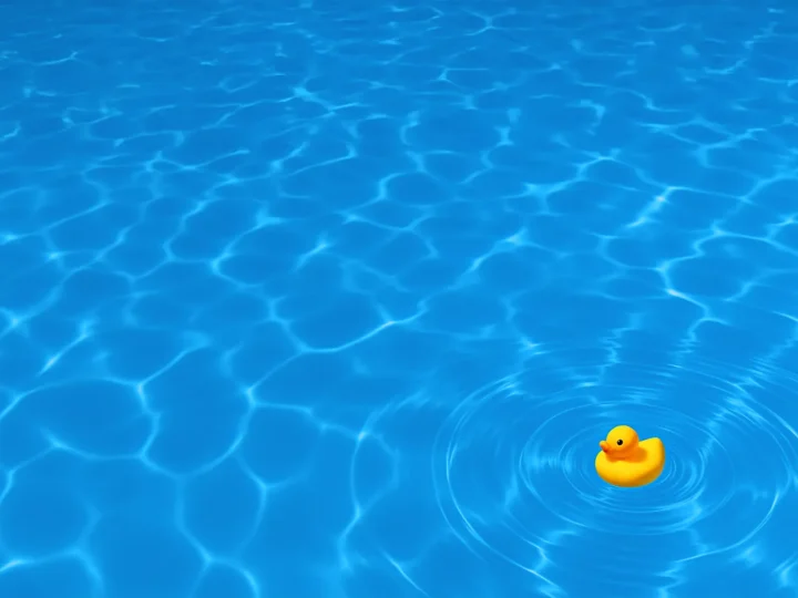 Minimalist photograph of bright blue water with a single yellow rubber duck floating near the lower right — a calm yet ironic reflection on surface and meaning.